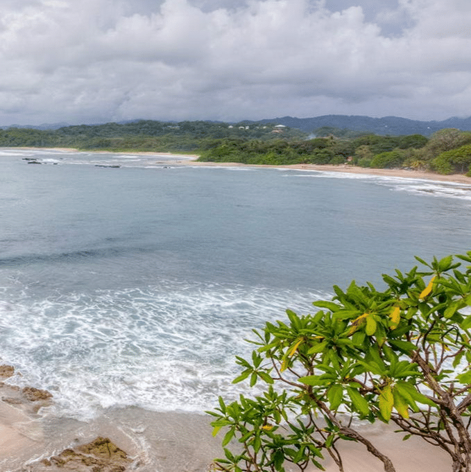 A tranquil beach in nosara, costa rica, with smooth sands and a vast open horizon.